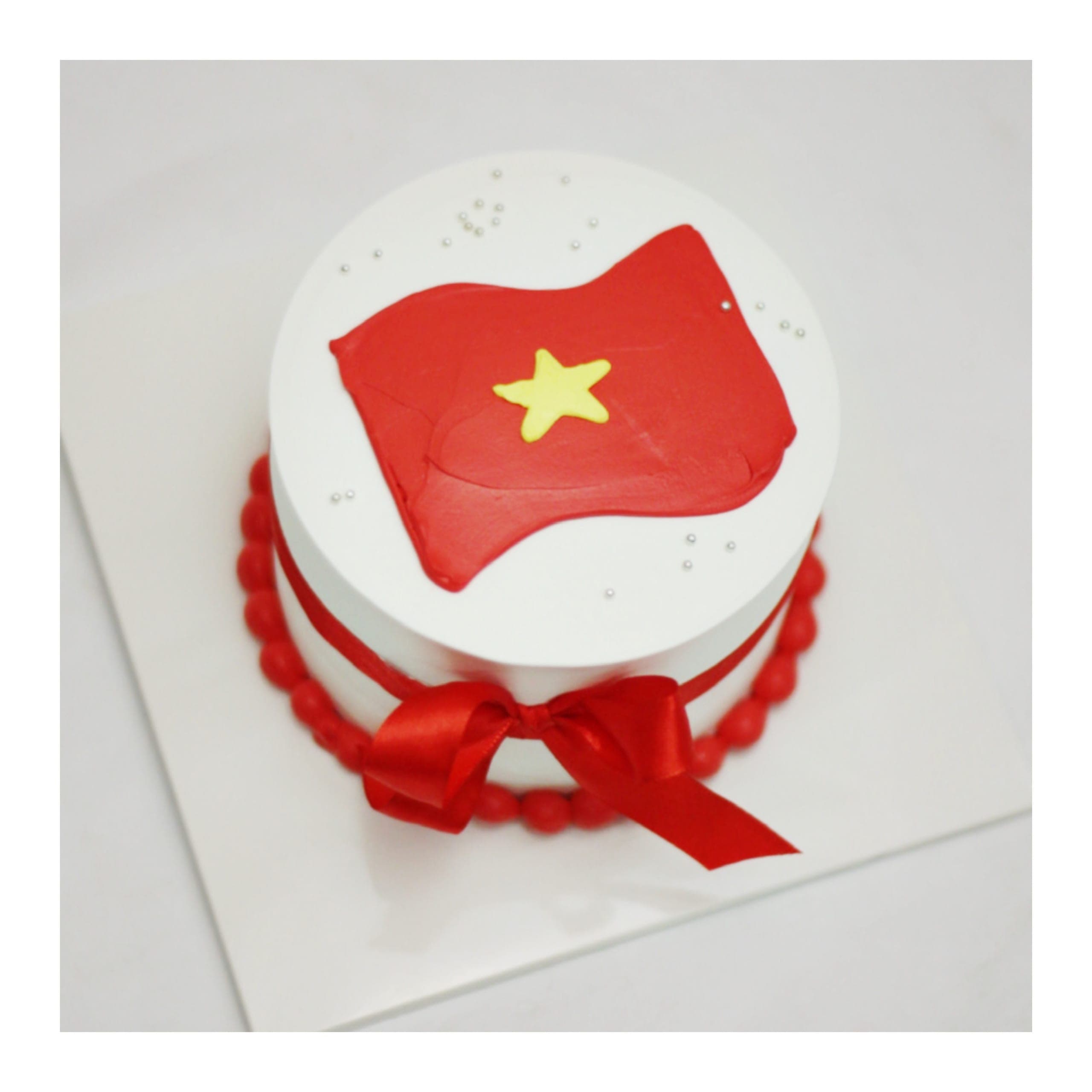 Bánh kem cờ đỏ sao vàng đính nơ đỏ