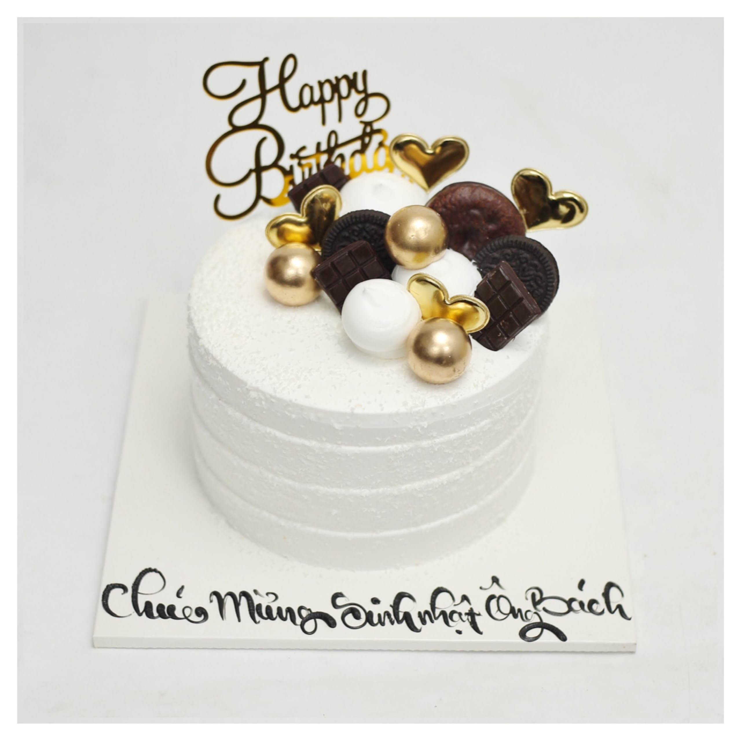 Bánh kem trắng trang trí socola và bi vàng