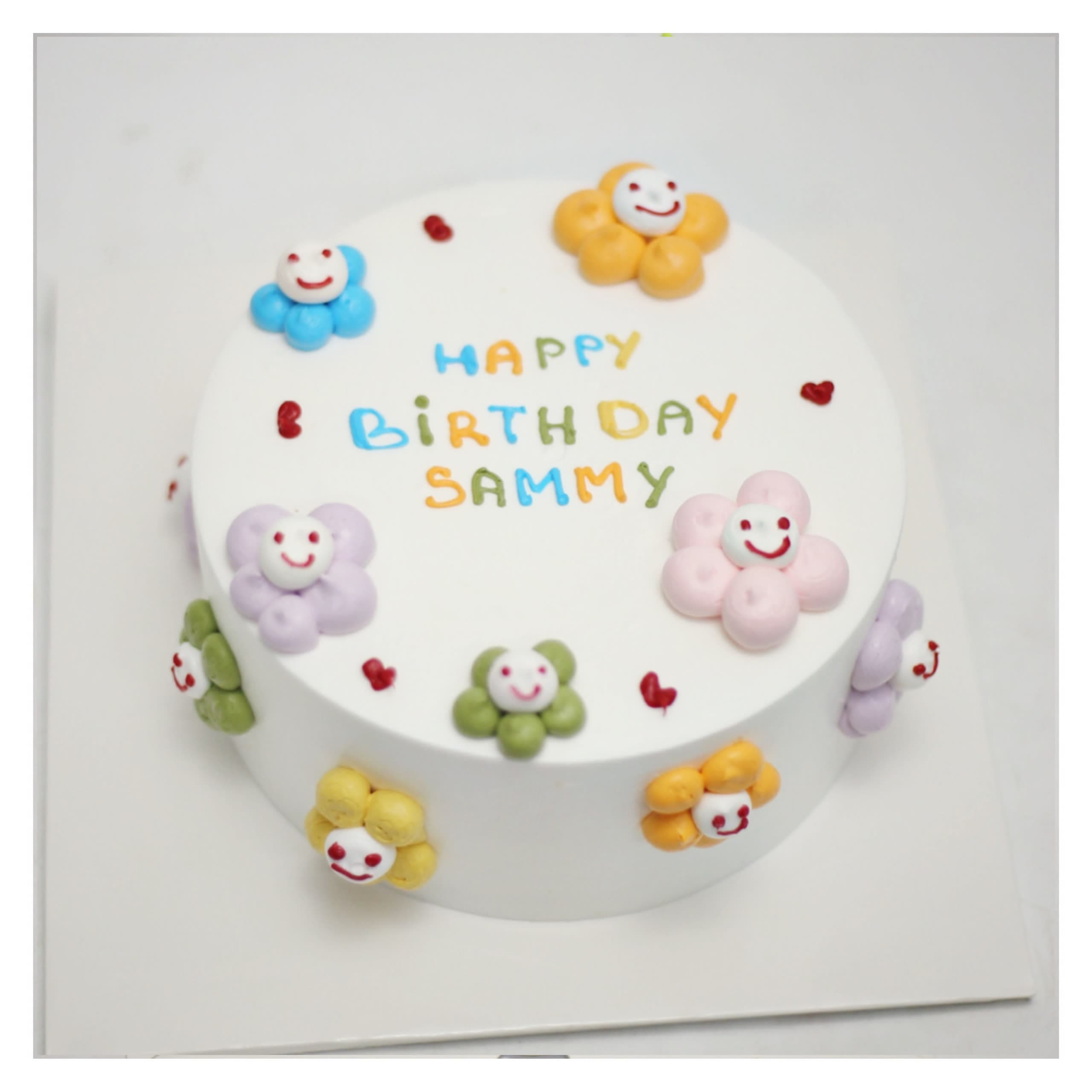 Bánh kem trắng trang trí hoa mặt cười