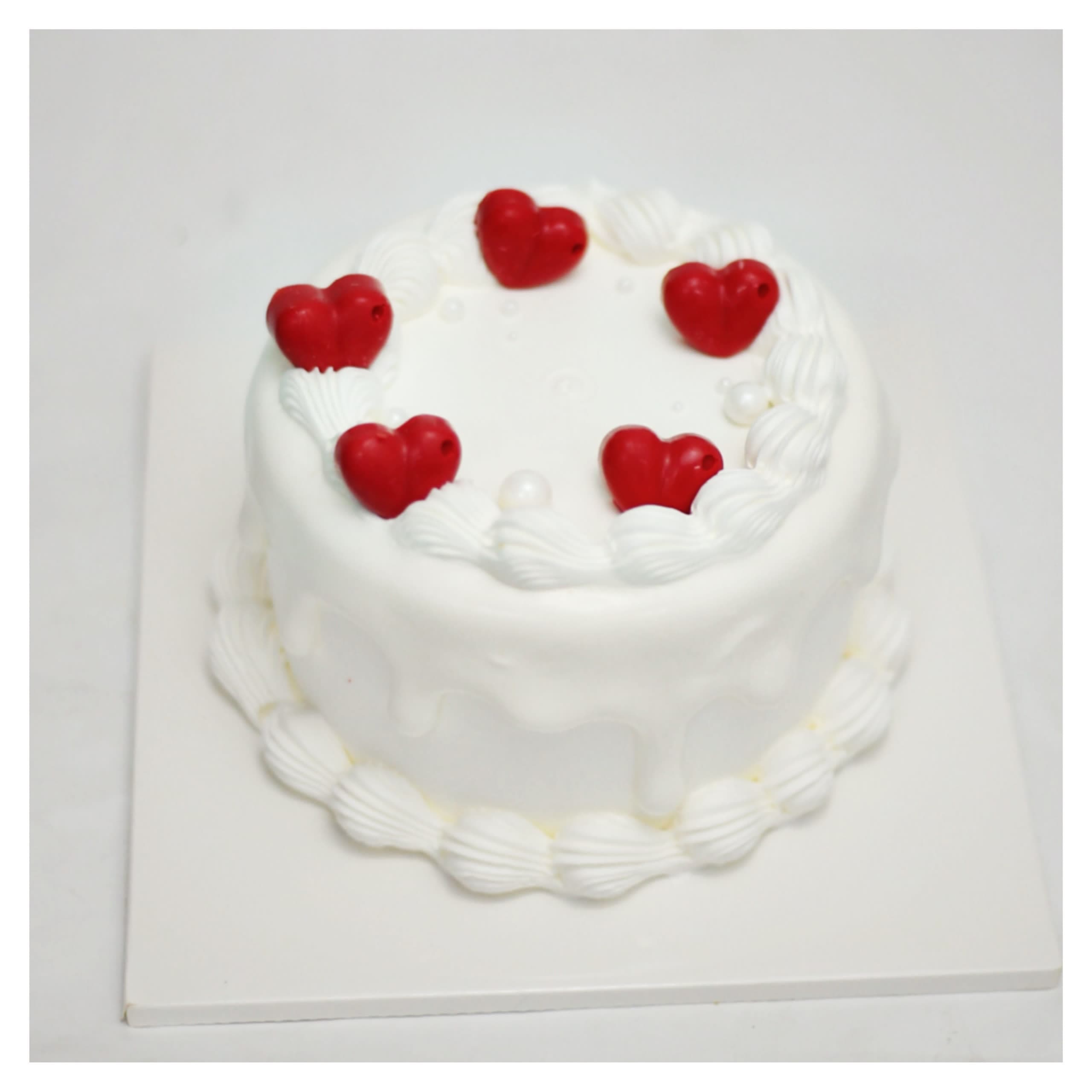 Bánh kem trắng điểm xuyết trái tim đỏ